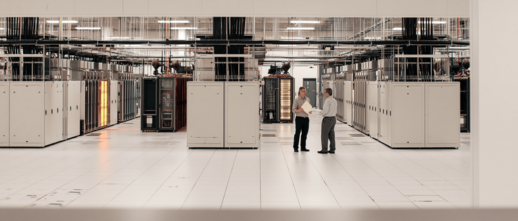Engineers reviewing structural load plans on a raised data center floor