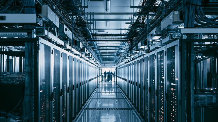Server racks on dollies in a colocation corridor between caged suites