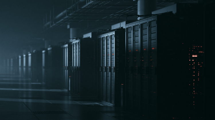 Server racks in a basement equipment room with water marks on the wall